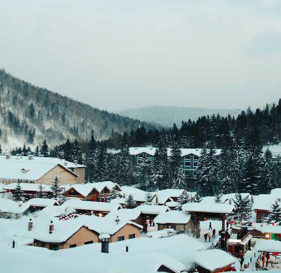 A small, snowy town at the base of a mountain.