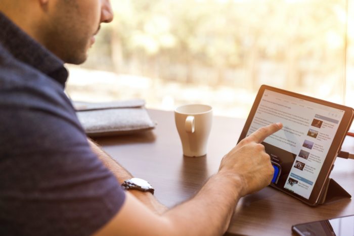 Man using LinkedIn on a tablet.