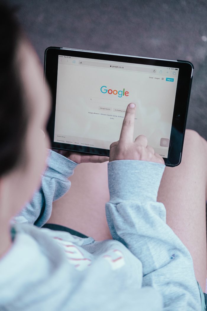 Girl holding tablet with Google pulled up