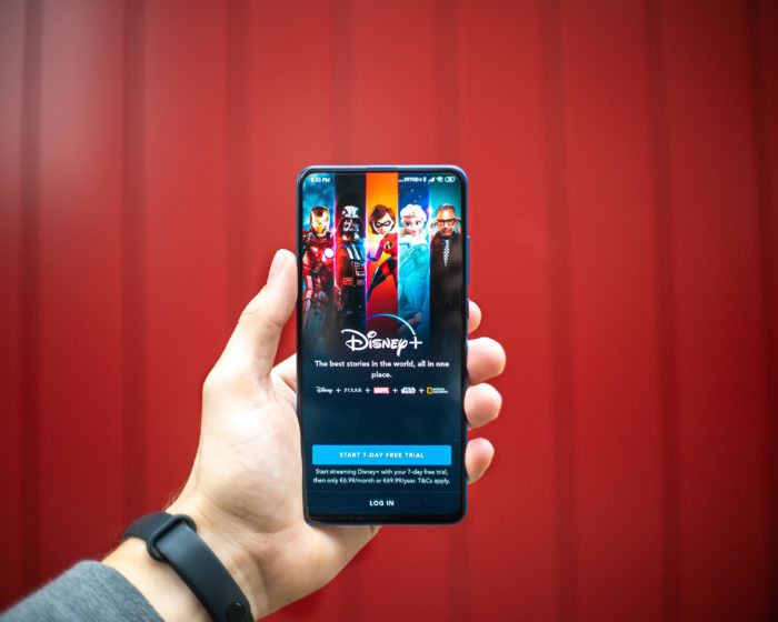 Hand holding cellphone showing Disney Plus app